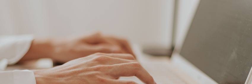 Hands typing on a laptop during a working session